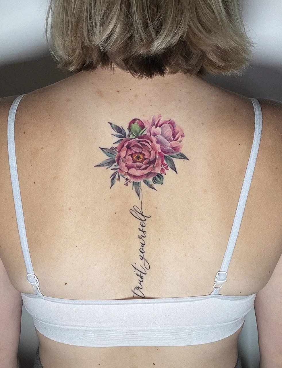 Vollständig verheiltes kleines Pfingstrosen-Tattoo mit feiner Schrift