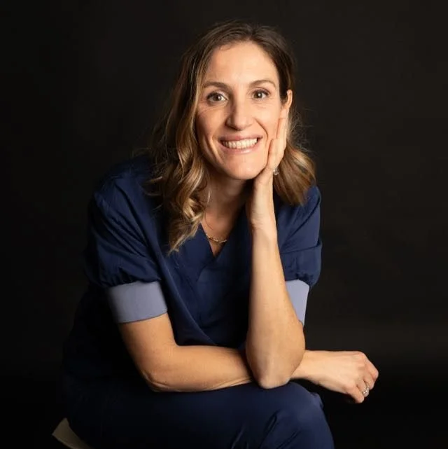 Le Dr Marta Misani, en tenue médicale assise contre un fond noir.