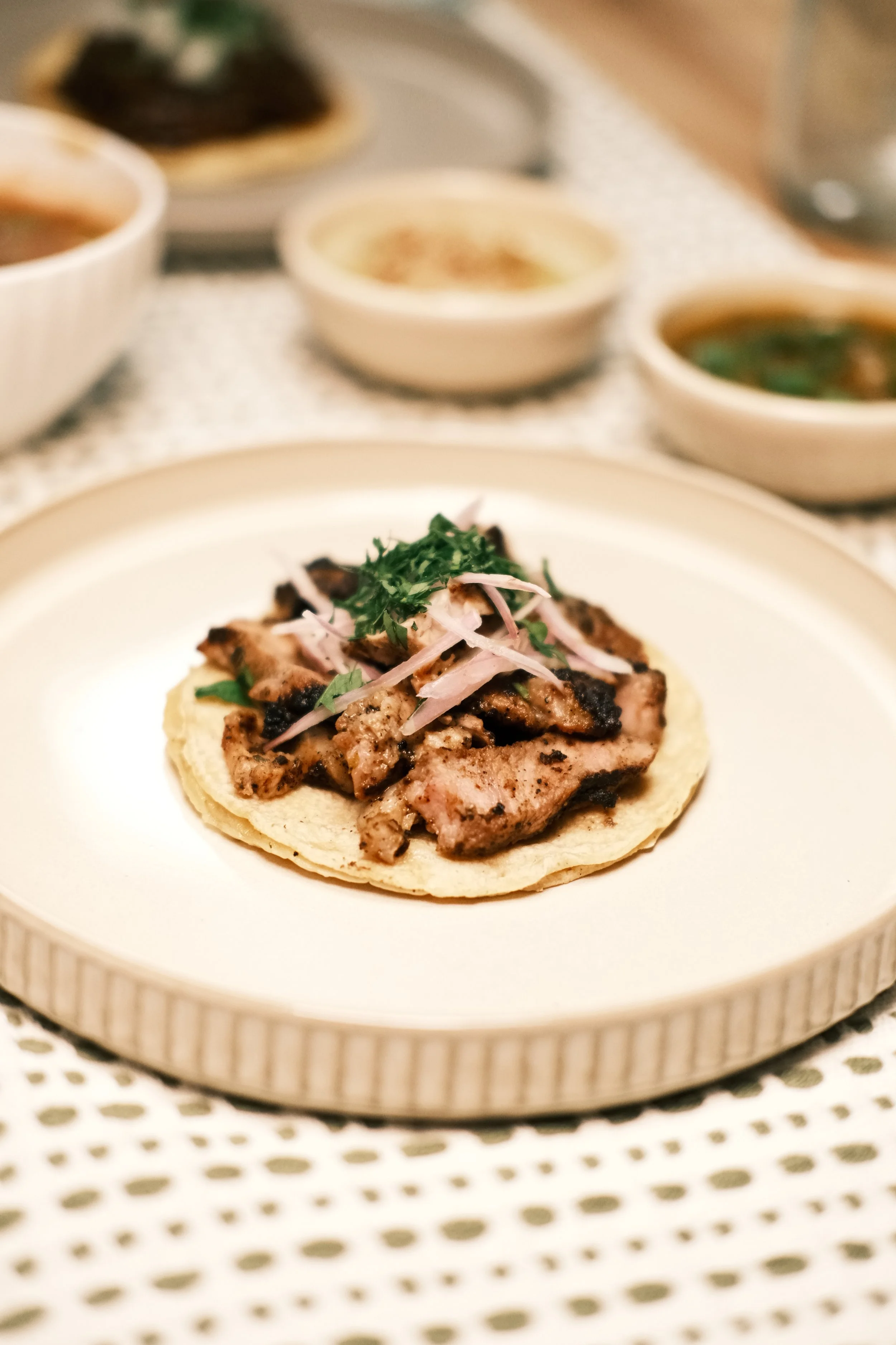 Grilled pork taco with pickled onion and cilantro on corn tortillas.
