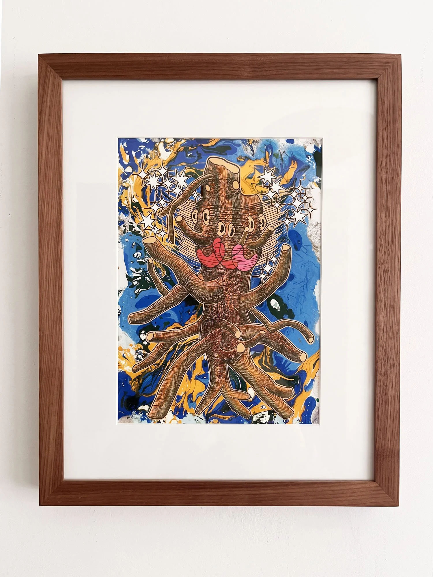 Framed colorful abstract artwork depicting a tree with roots and branches, with a vibrant background of blue, yellow, black, and white splashes.