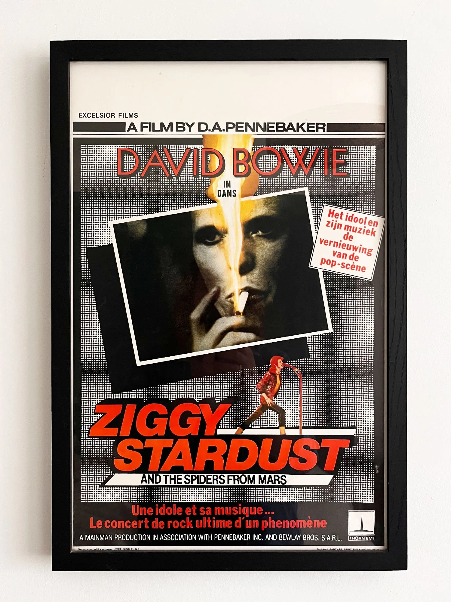 Movie poster for Ziggy Stardust and the Spiders from Mars in a black frame, featuring David Bowie with a cigarette, a woman in a red jacket, and concert details in French and English.