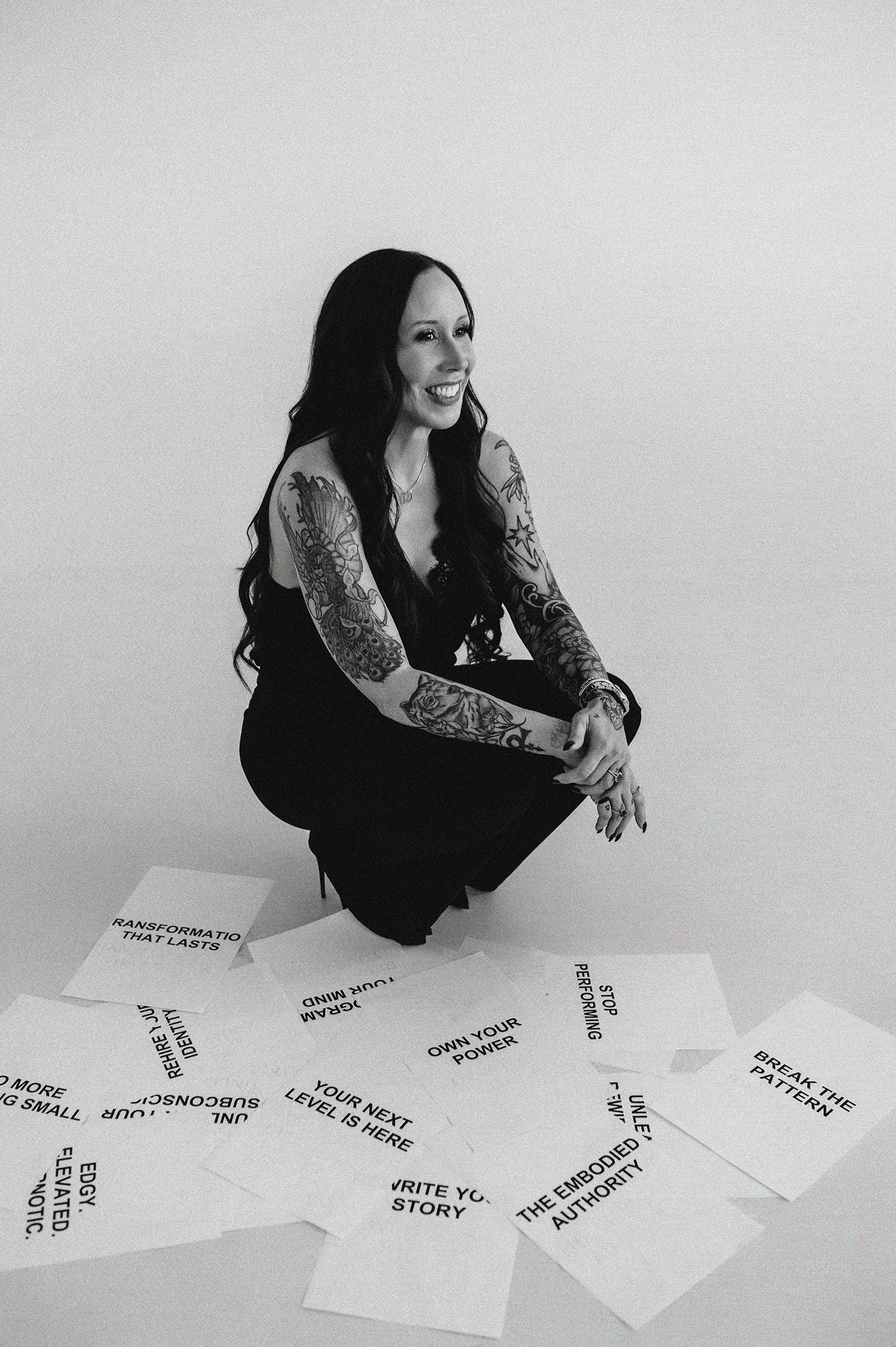 Photo of subconscious authority Tamara Rhodes, kneeling with papers showing motivational quotes