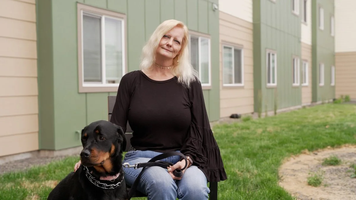 Community Frameworks resident, Tina, with her dog outside of Sinto Commons in Spokane, WA.