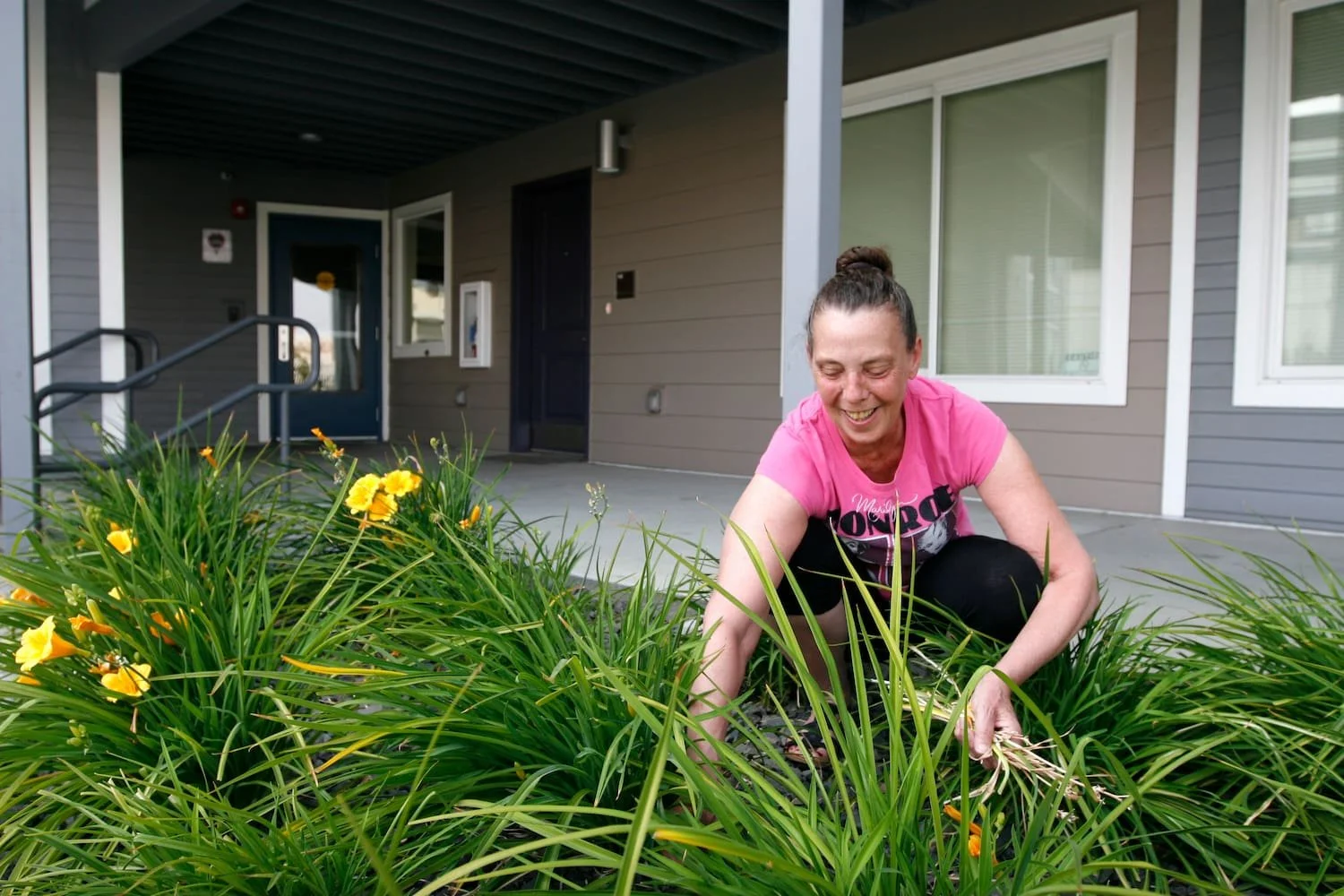 Woman weeding in garden of West 315 apartments in north Spokane, WA.