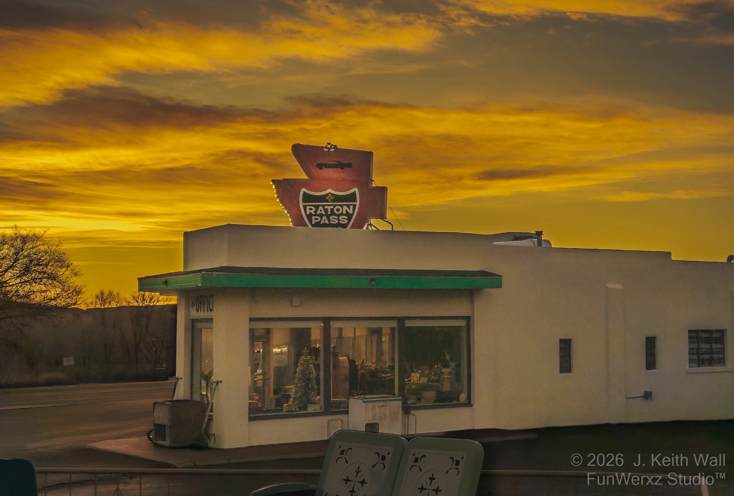Sunset sky over a building with a sign that reads "Raton Pass."