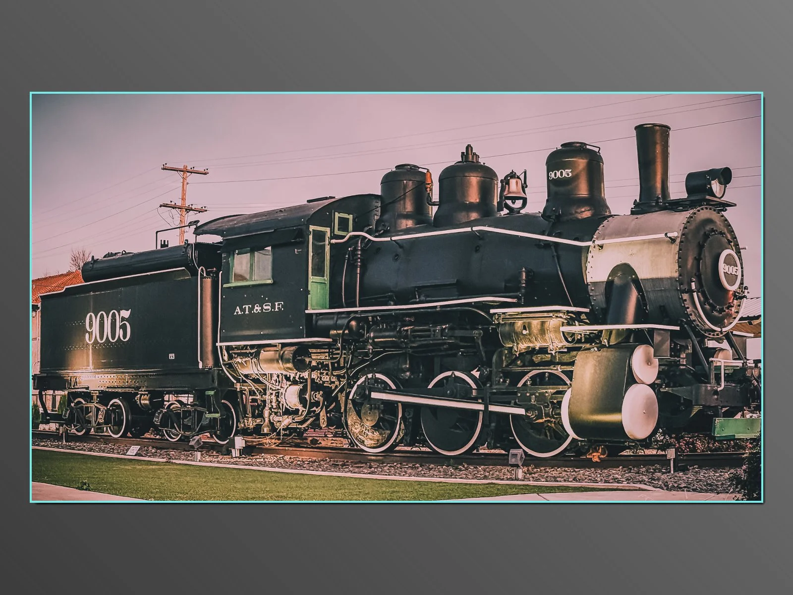 A vintage black steam locomotive with the number 9005 and the letters A.T.& S.F. is displayed outdoors, with utility poles and a pinkish sky in the background. Outside The Rails Restaurant in Clovis NM