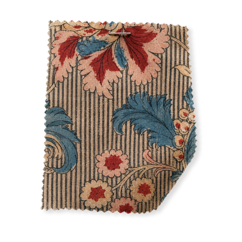 A torn piece of fabric with a floral pattern featuring red, pink, and blue flowers on a striped background.