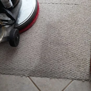Close-up of carpeted floor with a vacuum cleaner in the corner.