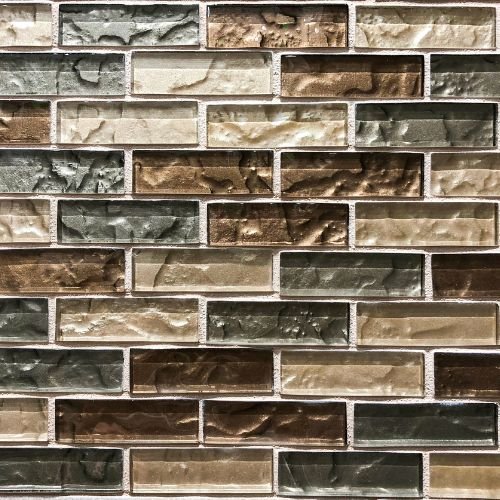Close-up of a brick wall with multicolored bricks in shades of brown, beige, and gray.