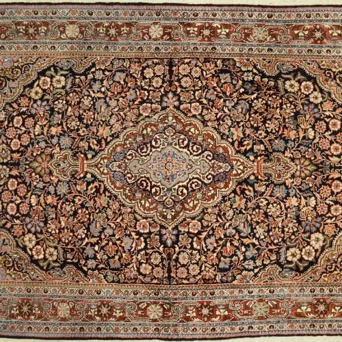 Close-up of a traditional Persian-style area rug with intricate floral patterns in red, black, beige, and blue.