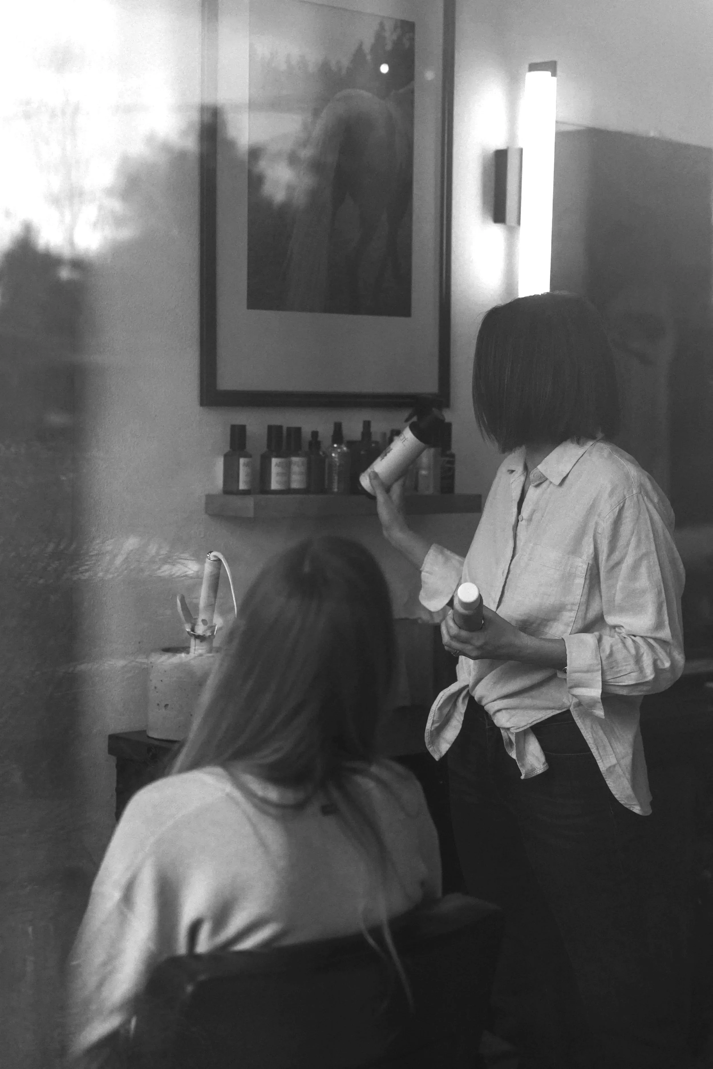 Stylist blow-drying a client with long keratin-tip hair extensions at Slate, Bend, Oregon