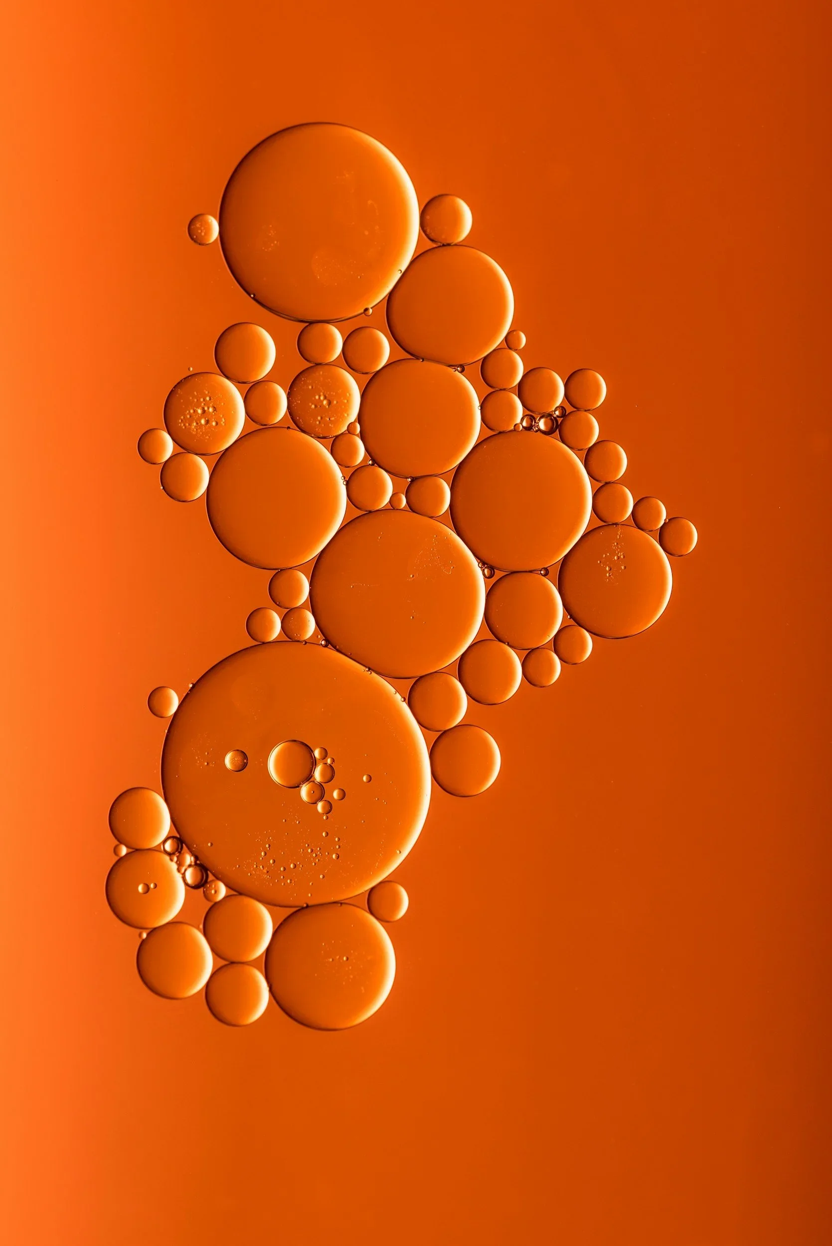 Close-up image of oil droplets on an orange background