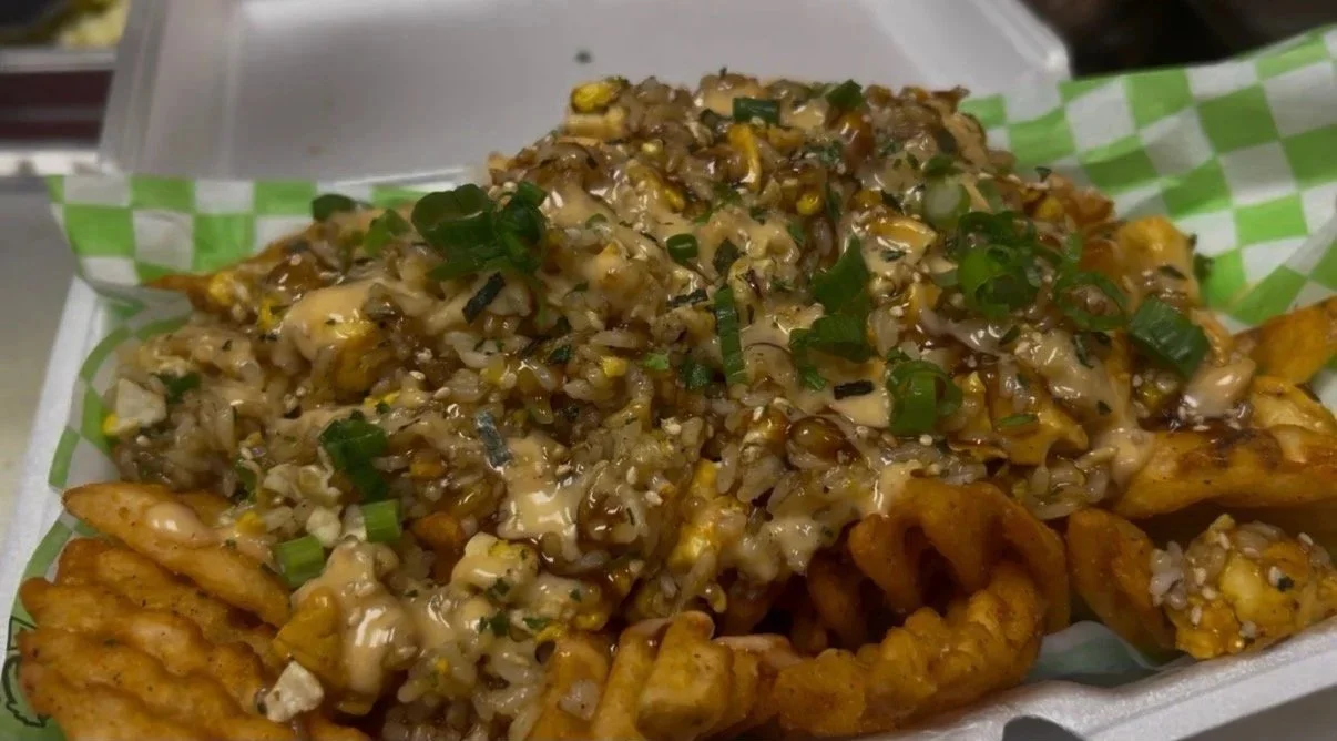 Fried chicken topped with gravy, chopped green onions, and a side of waffle fries