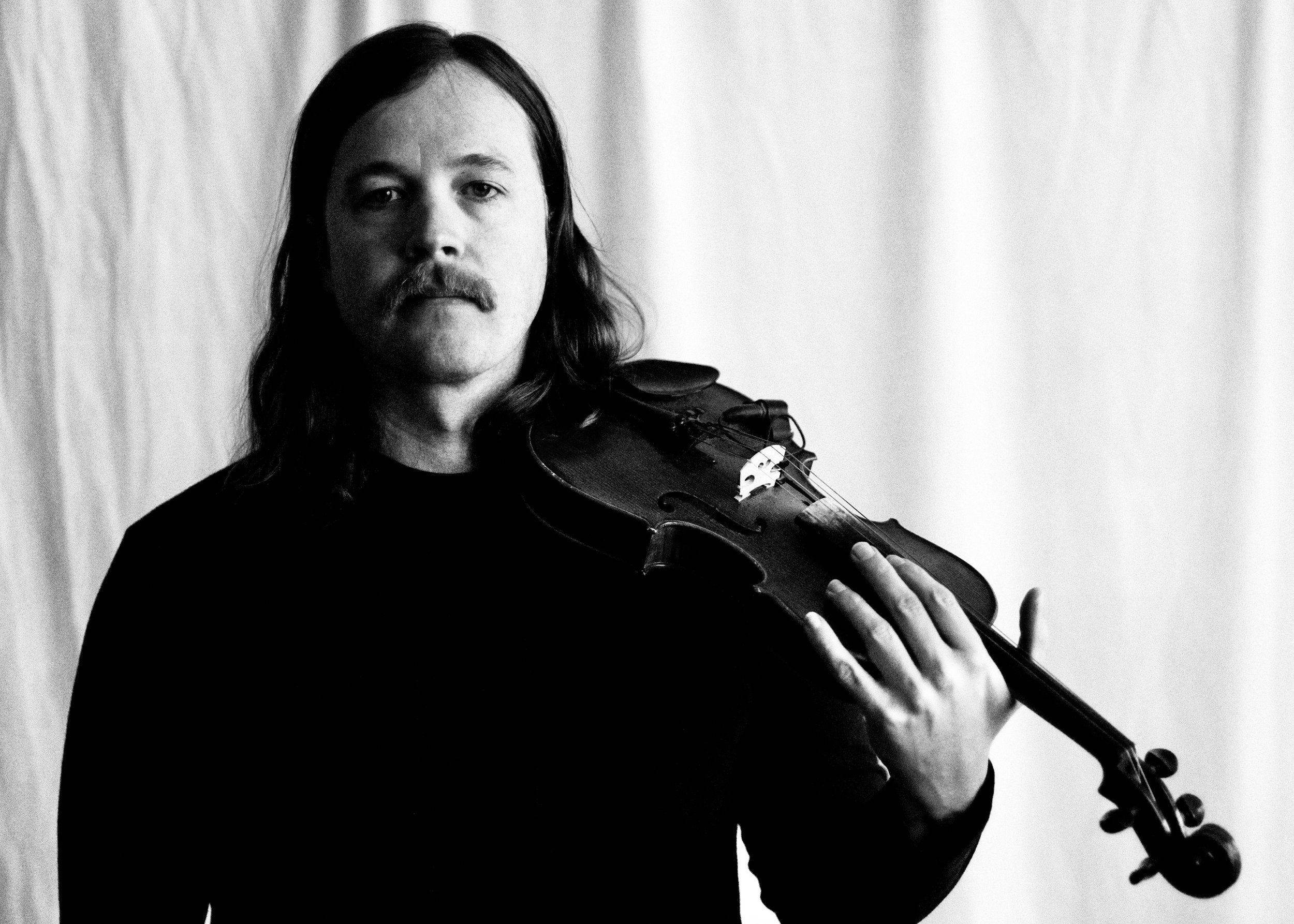 Black and white photo of Clayton Nile Young and his fiddle.