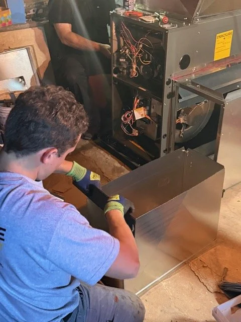 Prime Comfort technicians installing a new furnace in a Grand Rapids home