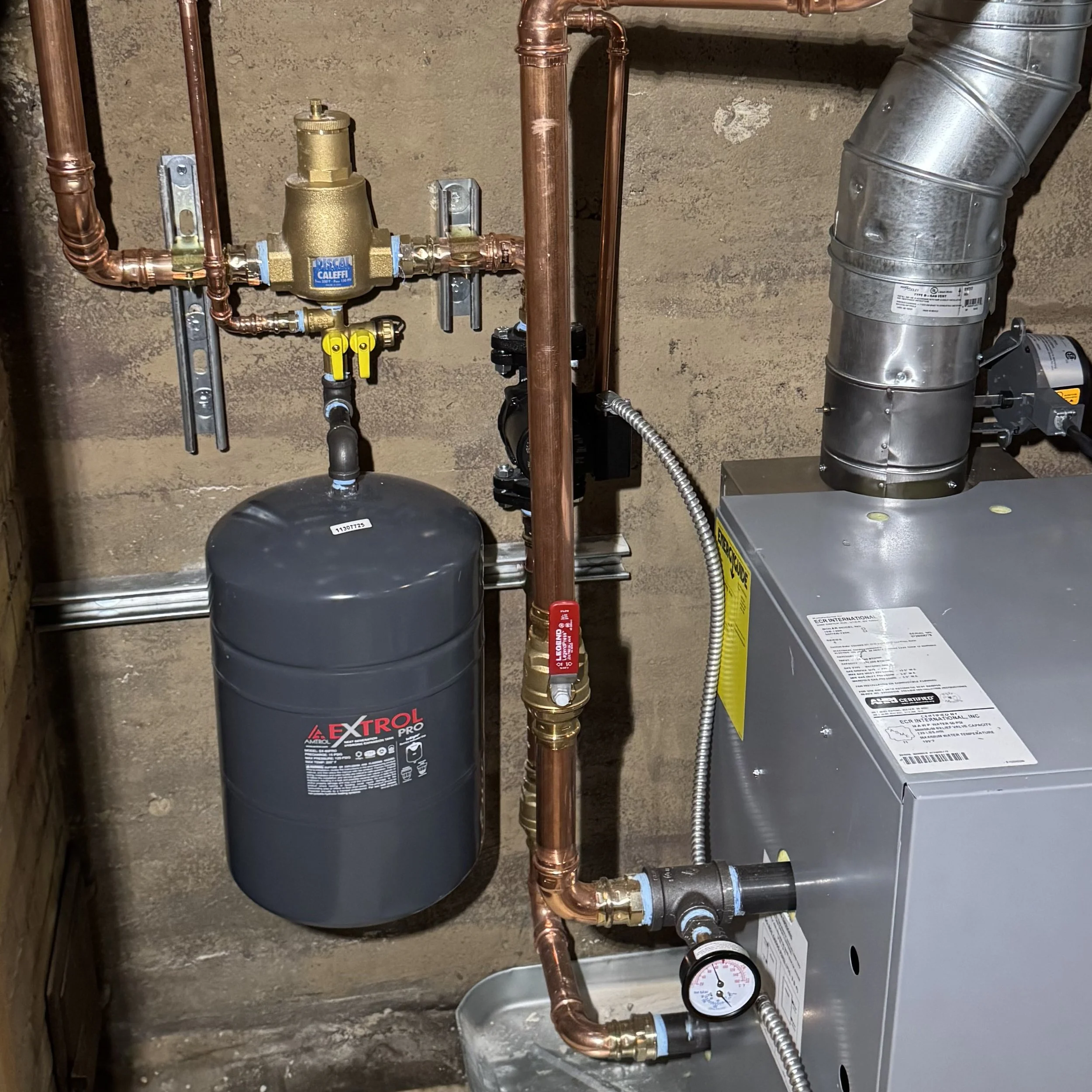 A newly replaced expansion tank with nearby piping