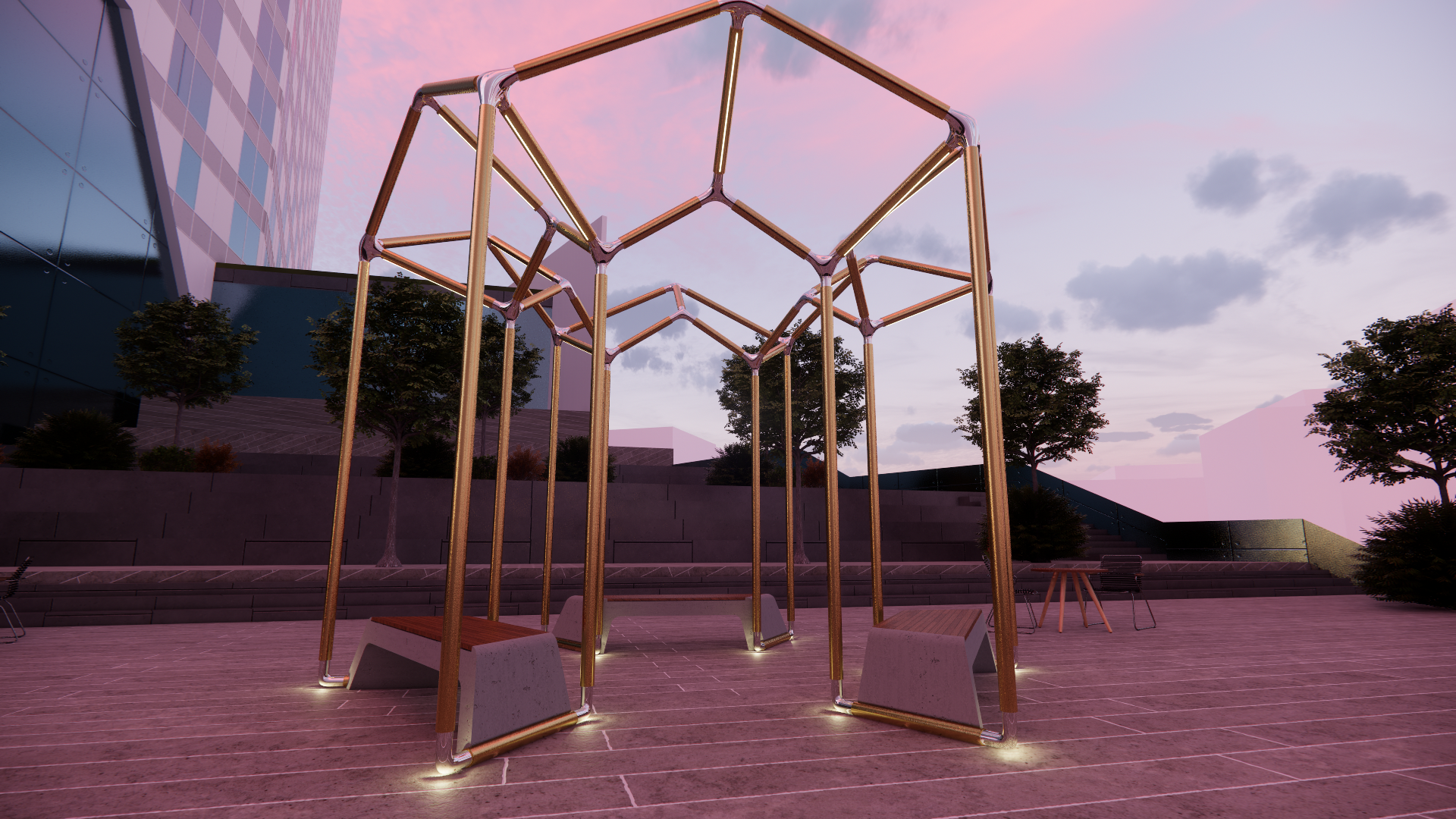 Modern outdoor park sculpture with interconnected copper-colored metal tubes forming a geometric structure, illuminated at the base, set against a cityscape with trees, benches, and a building with reflective glass windows at dusk.