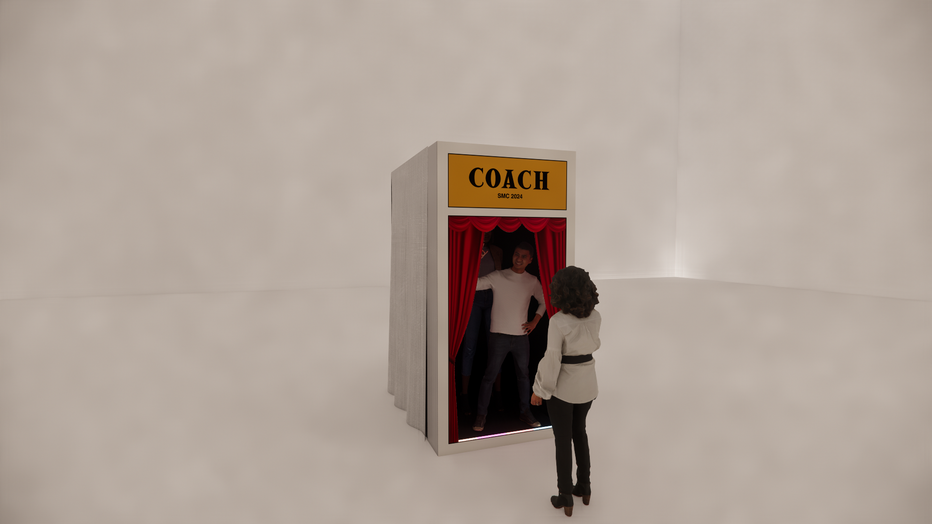 Miniature photo booth with a yellow sign that says "COACH SMC 2024" and red curtains, with two people inside and one person outside, in a plain white space.