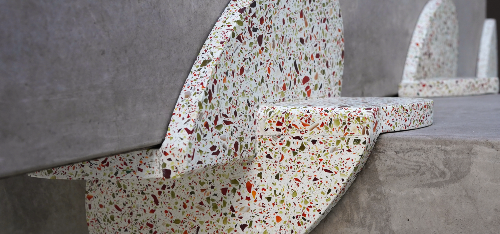Close-up of terrazzo benches with multicolored aggregate on concrete steps.