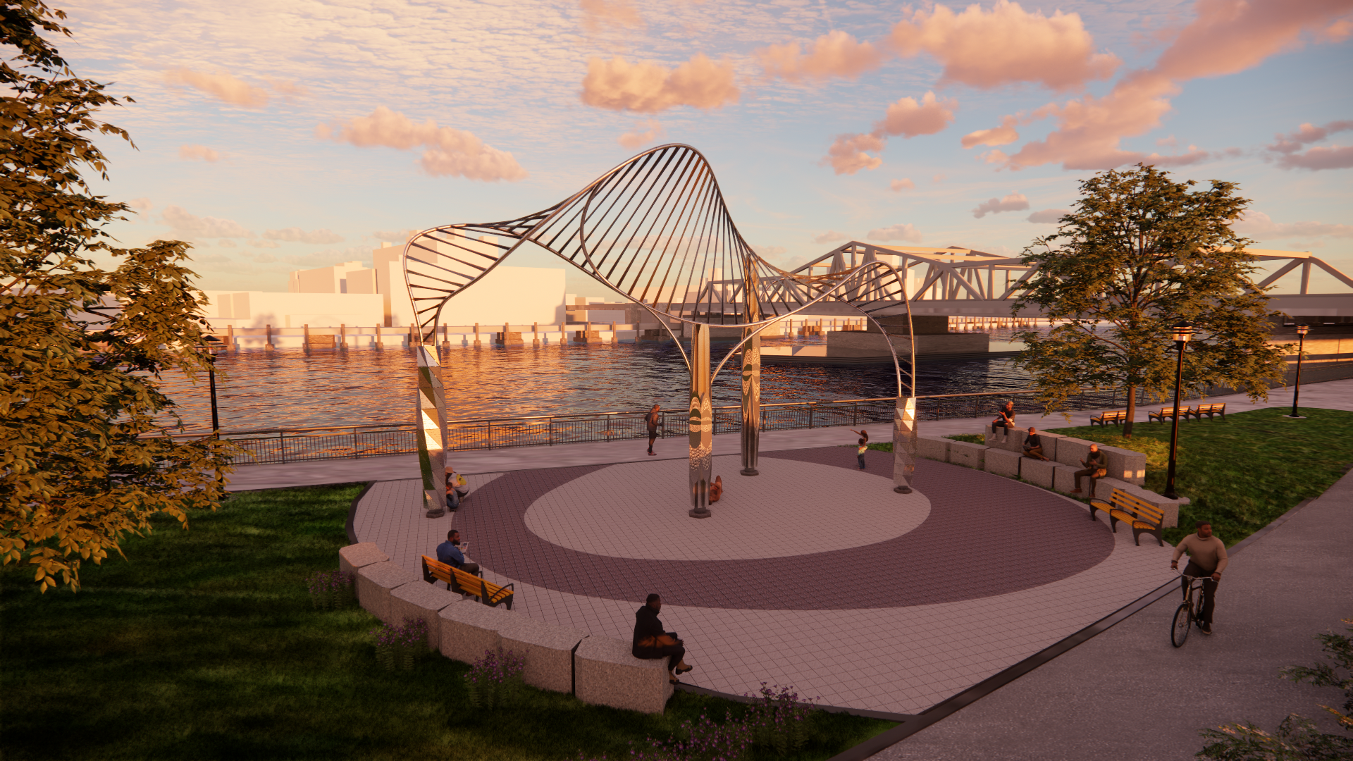 A park with a modern sculpture in the center near a waterfront during sunset, with people sitting on benches, walking, and cycling along the path.