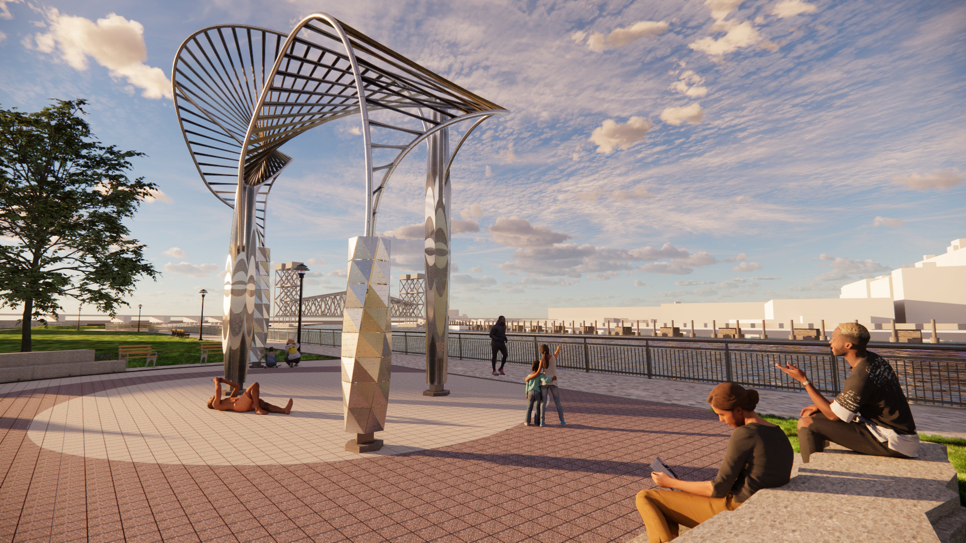 People relaxing and socializing in a park near a river, with a modern, artistic metal structure overhead and a railing along the water.