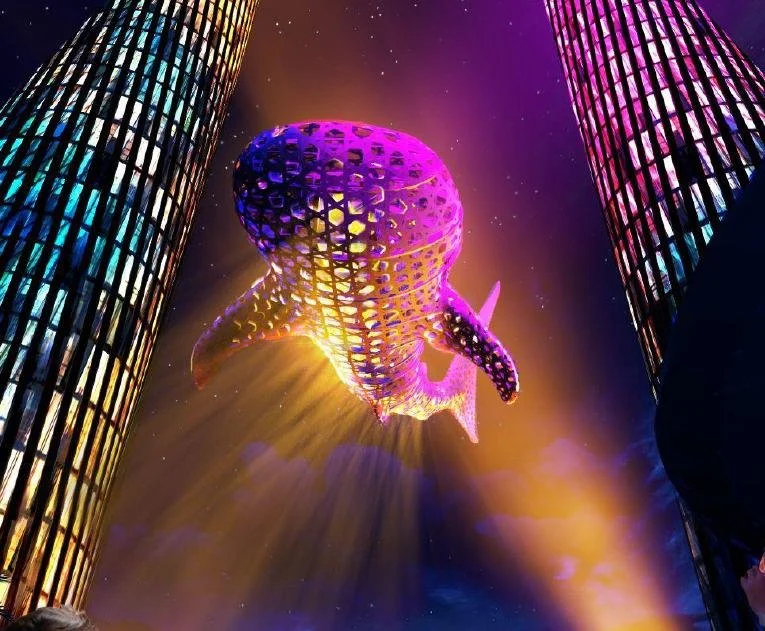 Colorful drone light show with a large octopus-shaped drone between two tall illuminated buildings at night.