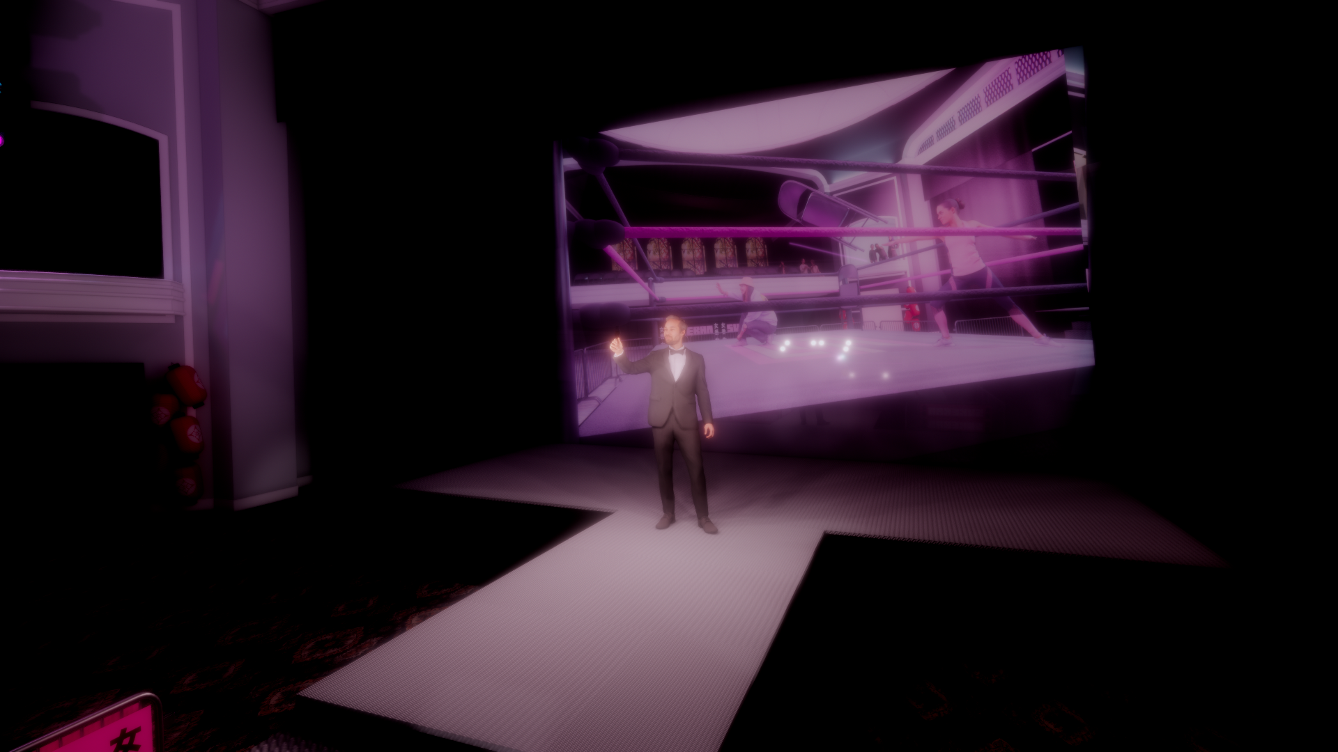 A man in a tuxedo standing on a stage in front of a large screen displaying a boxing ring scene with women exercising, in a dimly lit room with pink lighting.