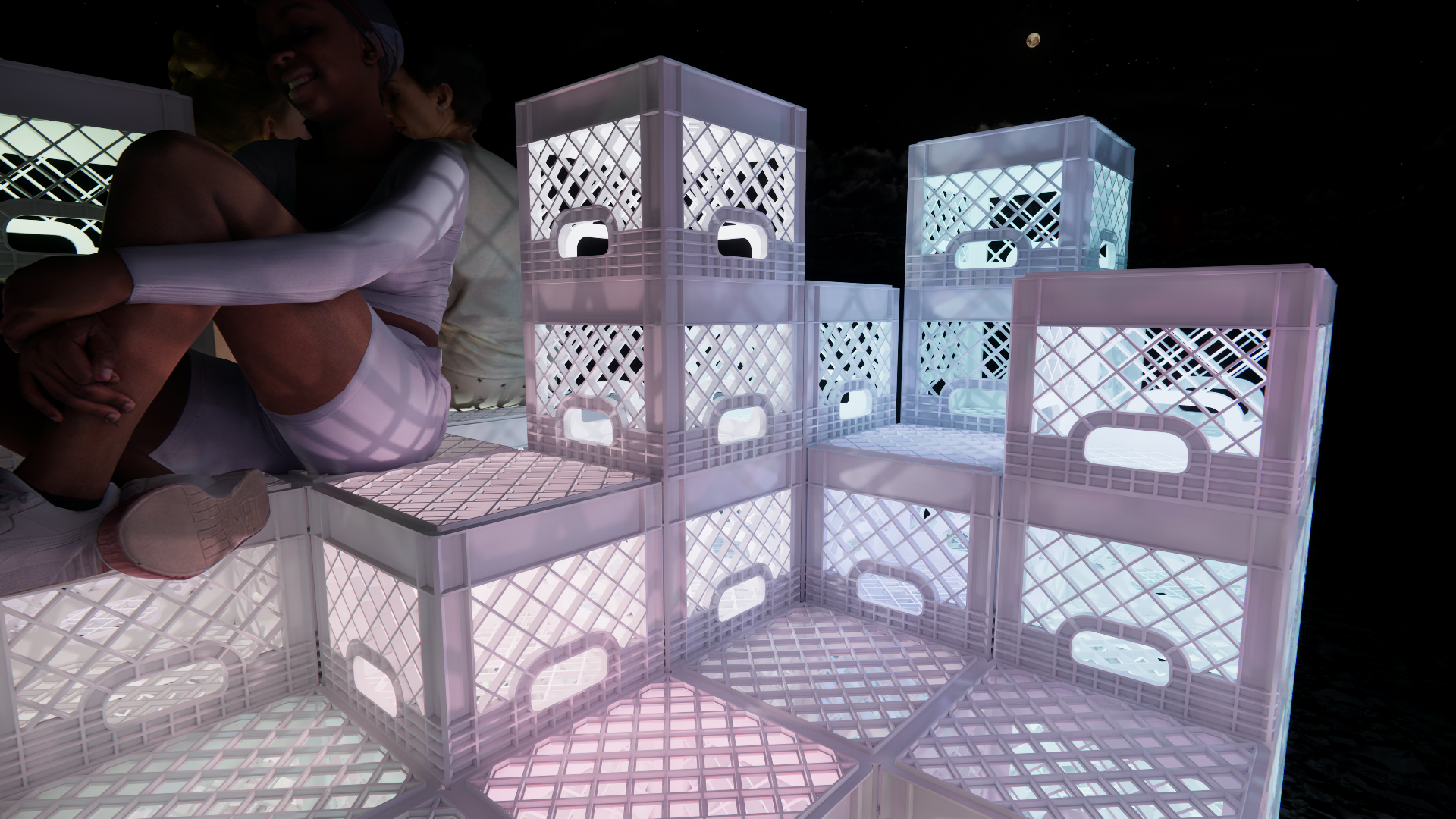 Two people sitting on a white, illuminated, multi-tiered plastic structure at night, with a dark sky and the moon visible in the background.