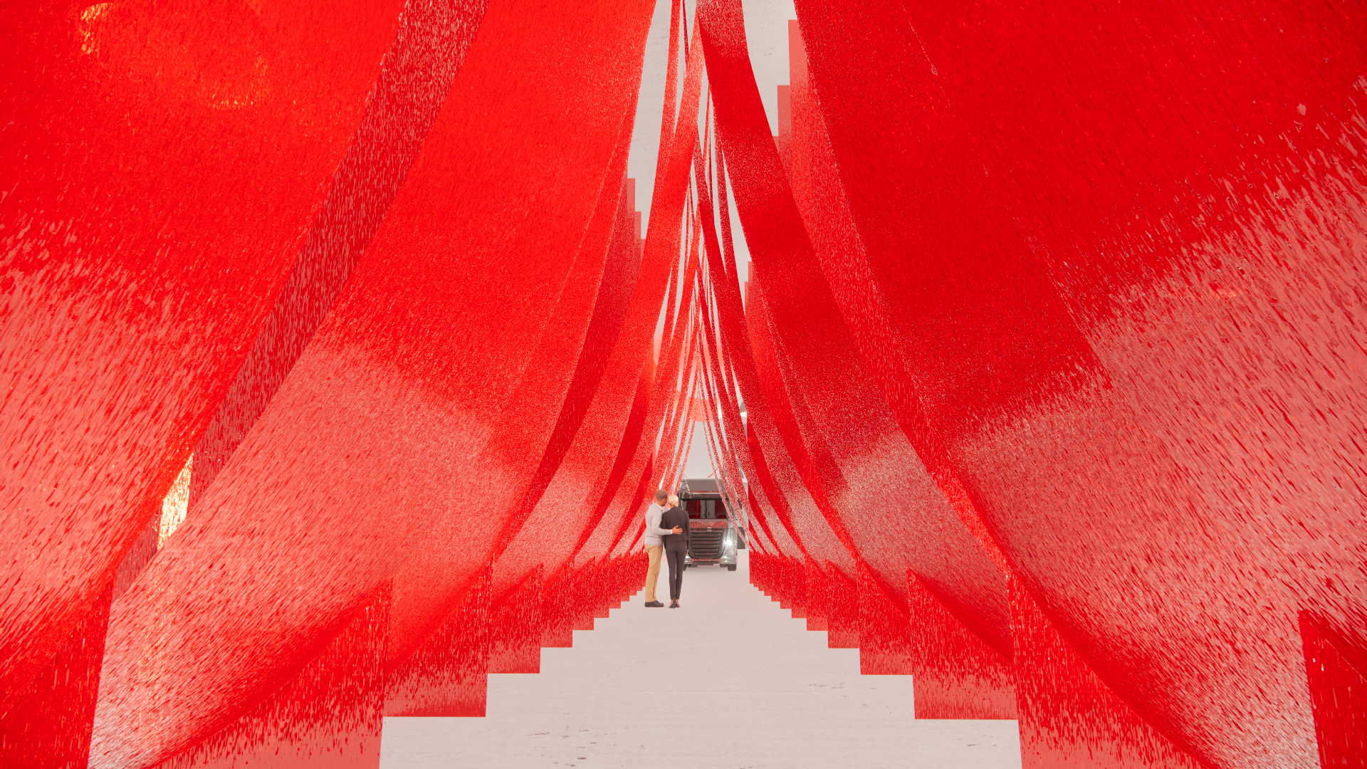 Two individuals standing in front of a large red installation made of elongated vertical panels with backside visible, with a truck parked behind them.