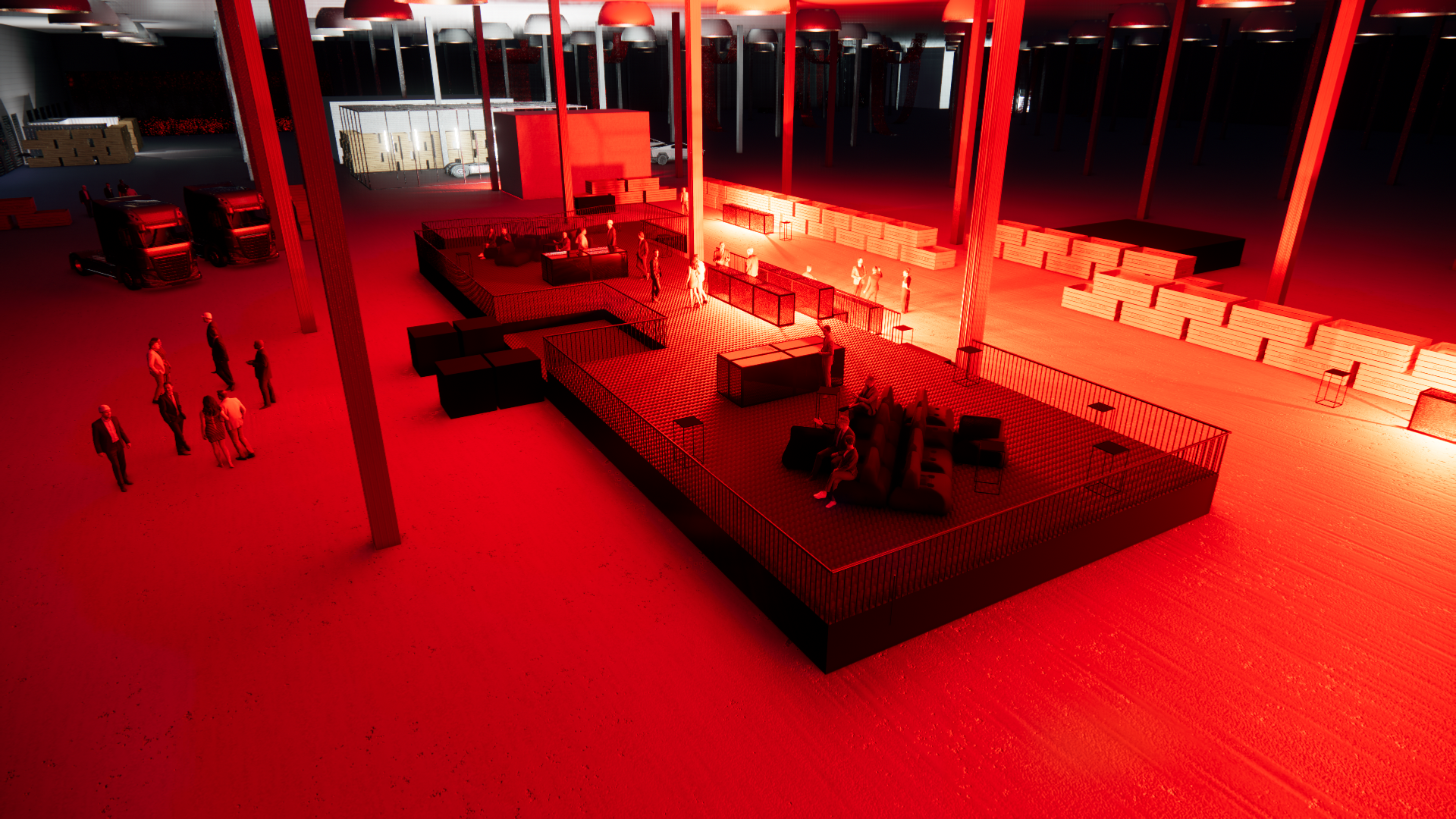 Interior of a large warehouse or event space with a red tint, people gathered on a designated area with seating, side tables, and a fenced-off section, and trucks parked on the left side.
