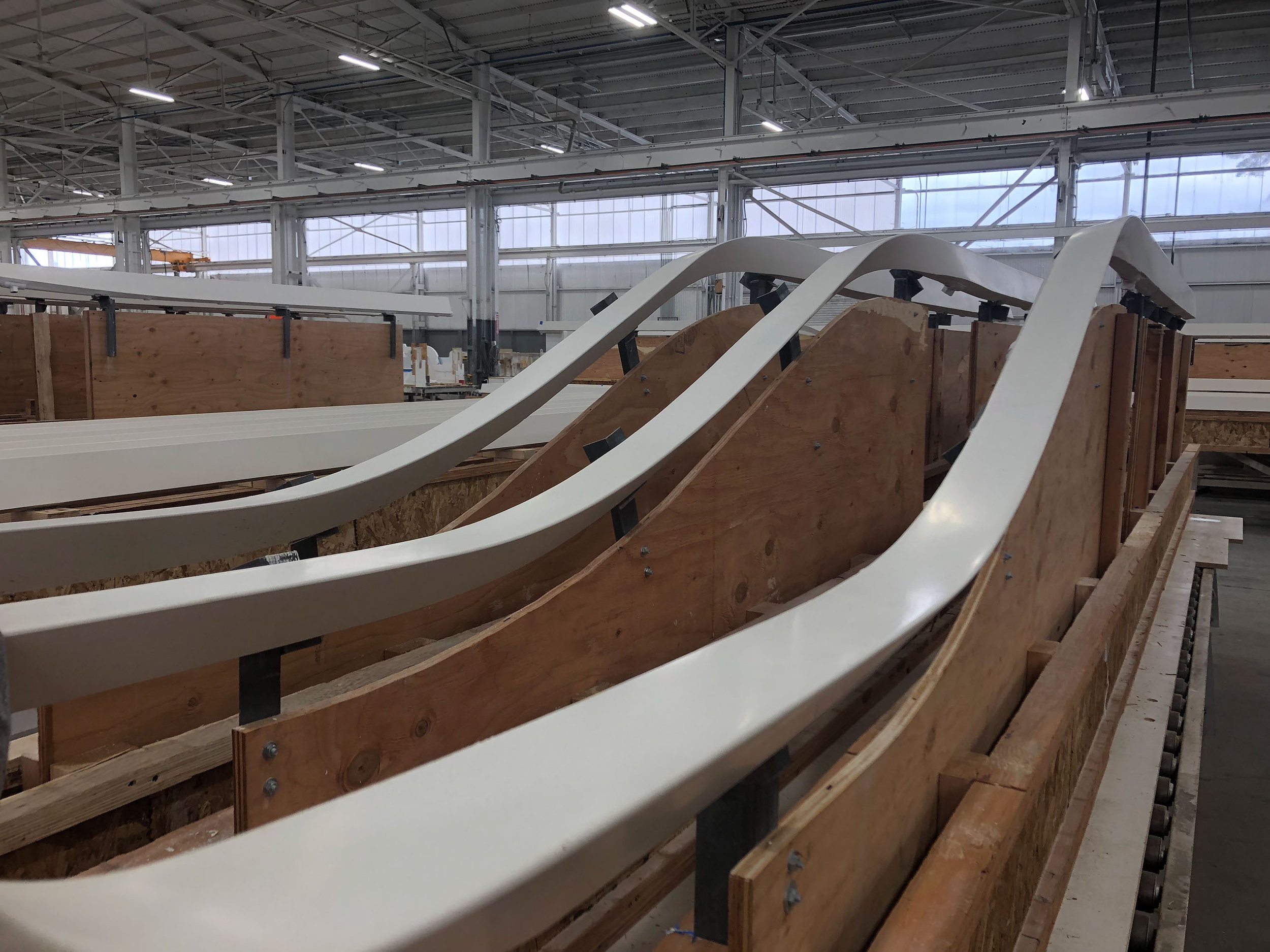 Under construction site with wooden and white structures inside a large industrial building.