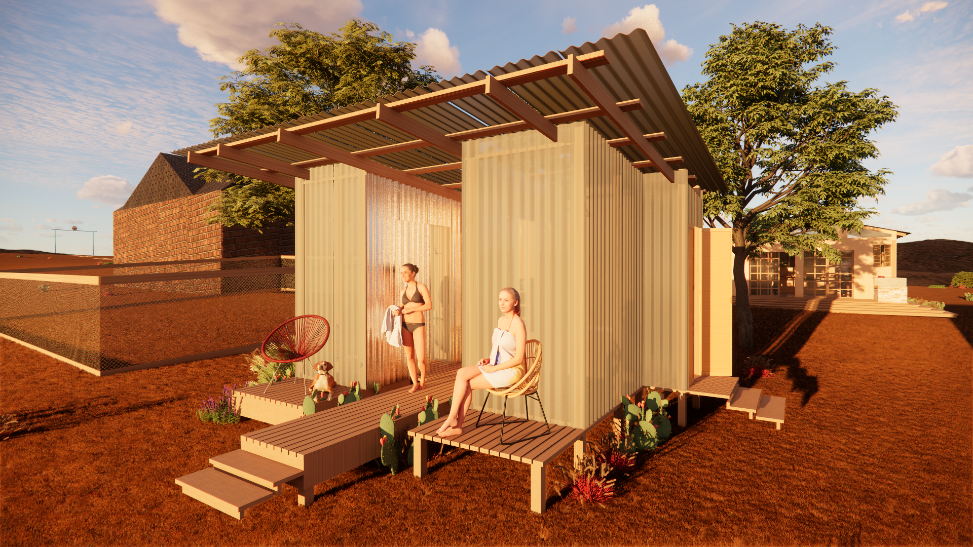 Two women in swimsuits relax on a porch of a modern, rustic tiny house made of corrugated metal with a wooden roof extension, surrounded by desert landscape with trees and neighboring houses in the background, during sunset.