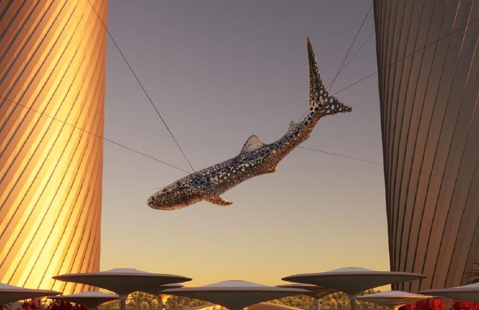 Large whale-shaped art sculpture suspended between two tall, modern buildings with a sunset sky in the background.