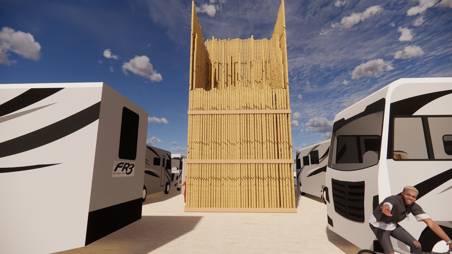 Group of RVs parked in an outdoor lot with a tall wooden structure in the background and a smiling man crouching near the right side of the image.