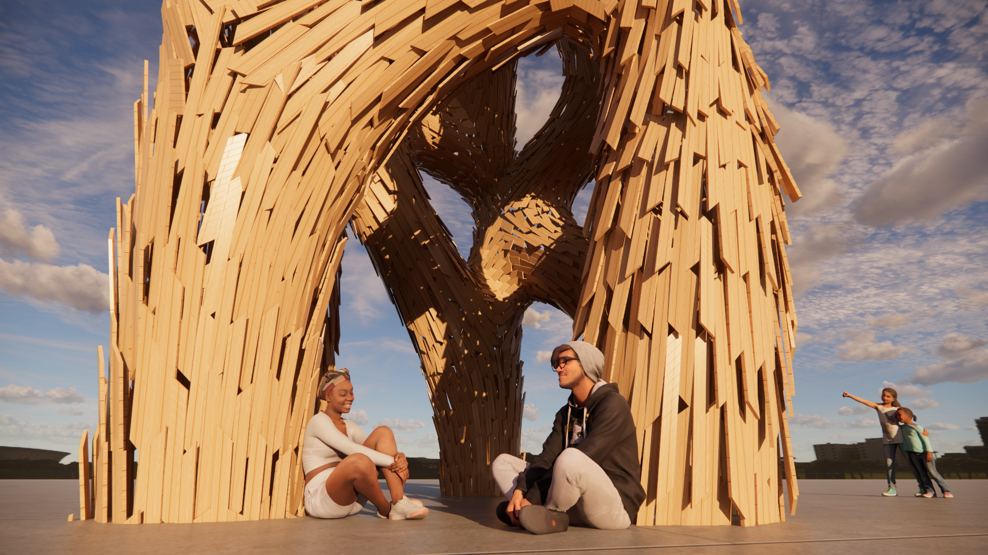 People sitting and chatting under a large wooden structure resembling a heart shape, with children playing nearby, against a partly cloudy sky.