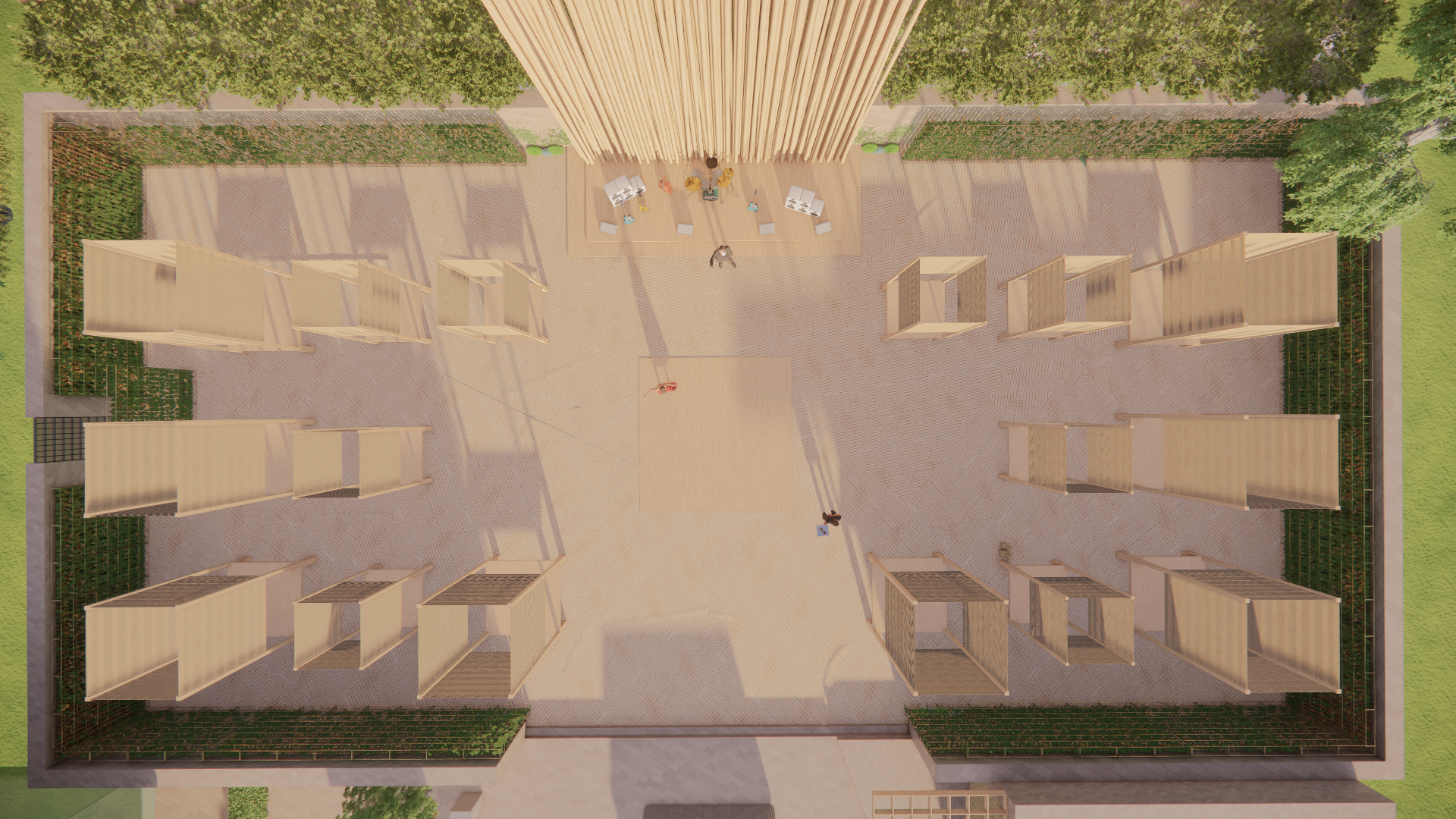 Aerial view of an outdoor event space with wooden partitioned booths surrounding a central open area, green hedges, and a stage with a group of people seated.