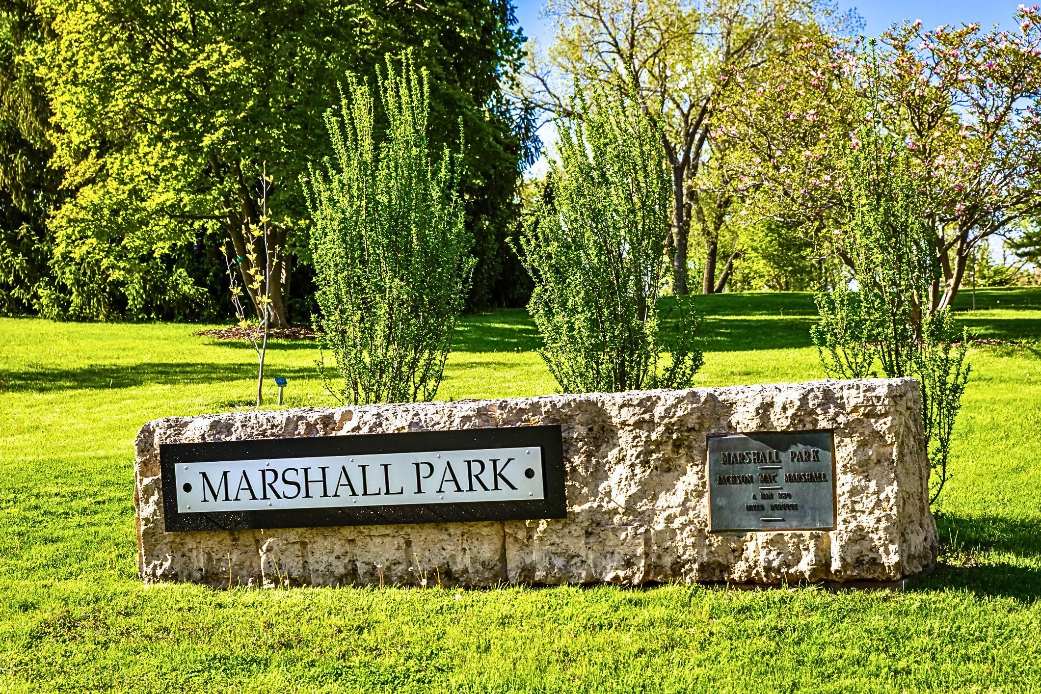 Sign for Marshall Park with greenery in background.