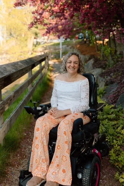 Smiling woman in wheelchair outside on hiking trail