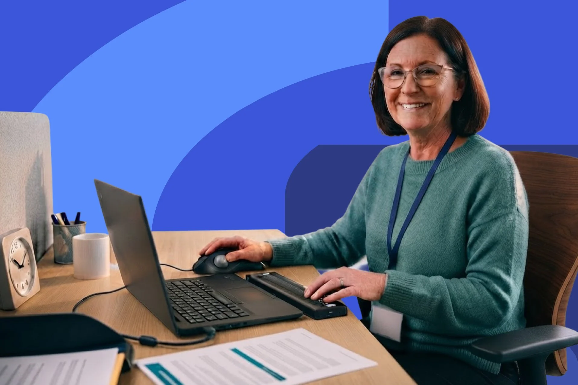 a friendly woman at a desk with a laptop ready to offer support