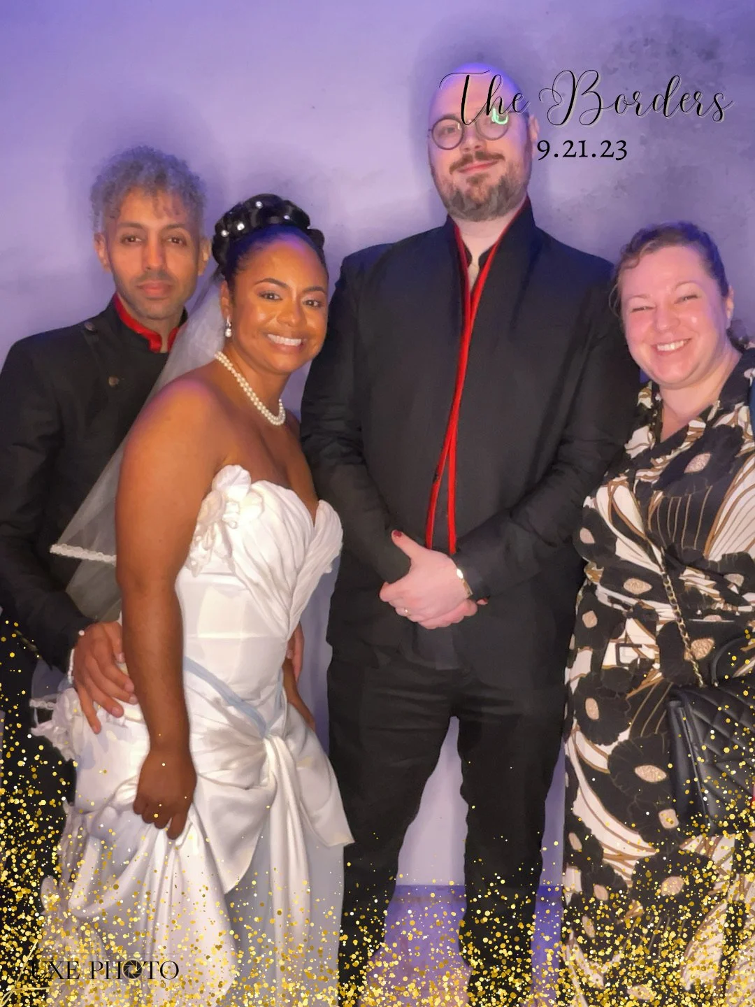 Four people are standing together, two of them are dressed in formal attire, one in a wedding dress and the others in suits, with a purple background and golden glitter border, and text that says 'The Borders 9.21.23'.