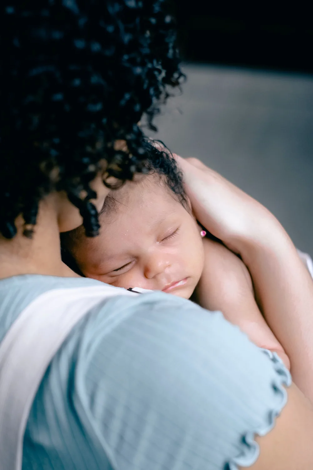 A parent holding a sleeping newborn