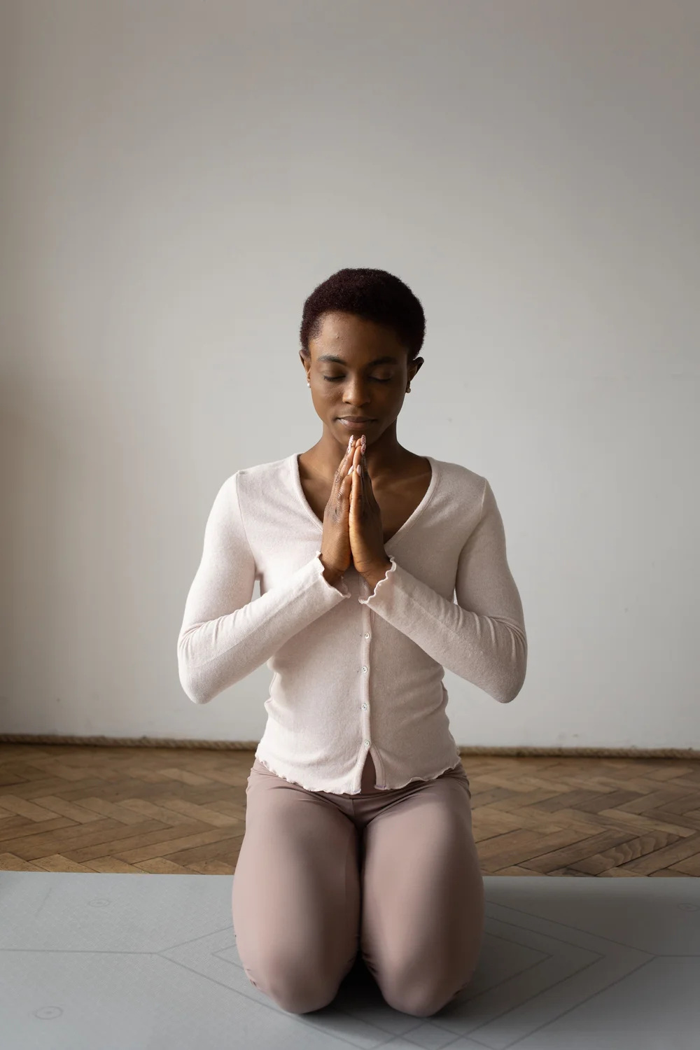A woman kneeling with her hands together