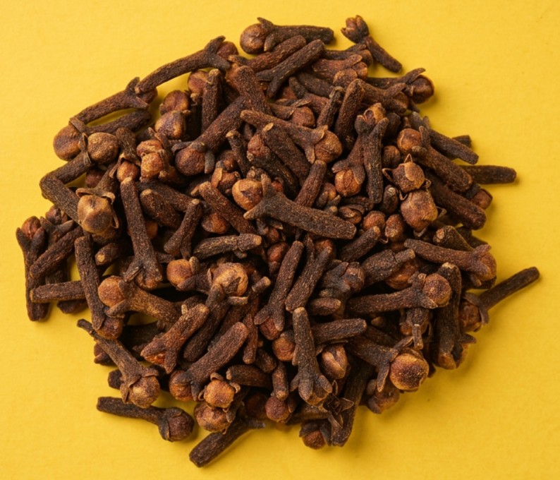 Close-up of dried cloves on a yellow background.