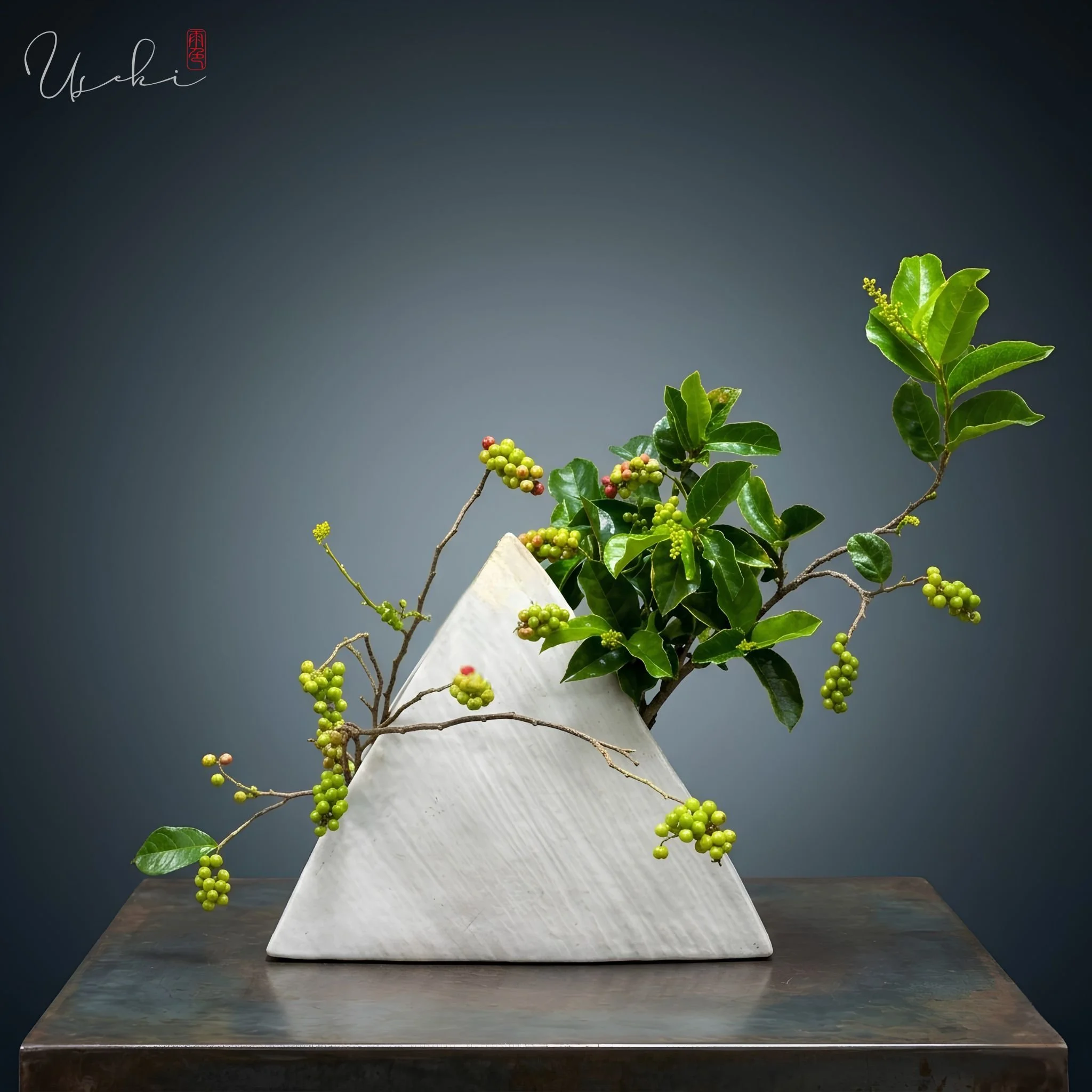 Sogetsu Ikebana geometric triangular ceramic vase display with fresh green leafy branches