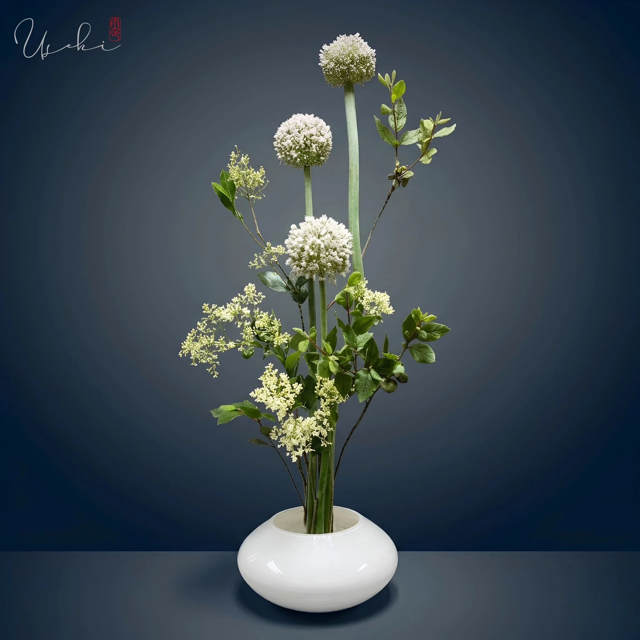 Sogetsu Ikebana white round vase sculpture featuring tall vertical onions and green clusters