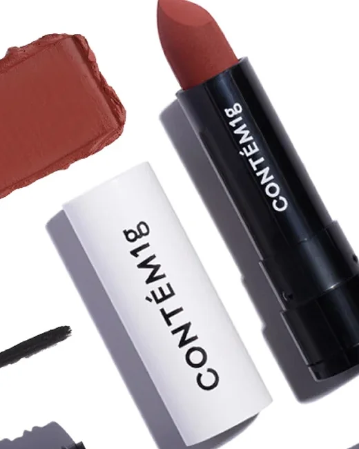 Batom de cor marsala ao lado de um lip balm com embalagem branco e preto que tem a marca "CONTÉM 1 G".