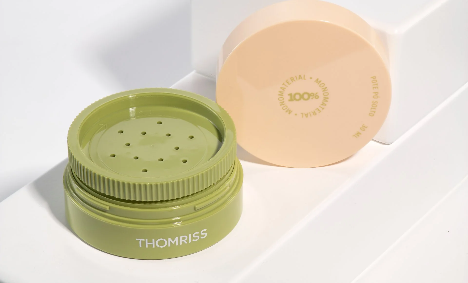 Embalagem de Pó compacto sustentável com tampa verde e pote de creme ou loção com rótulo bege.