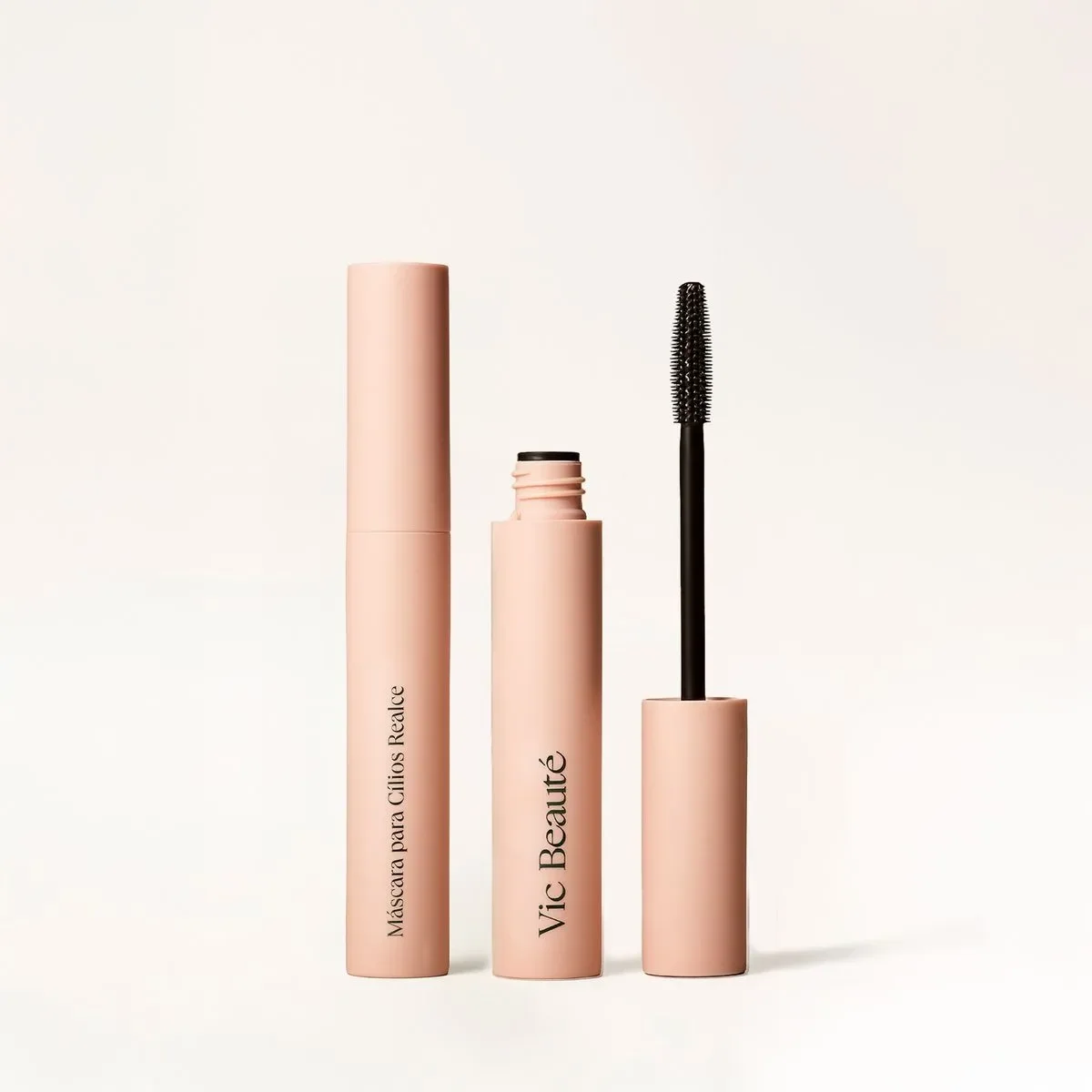 Rímel rosa da marca Vic Beauty com o aplicador ao lado, em fundo claro.