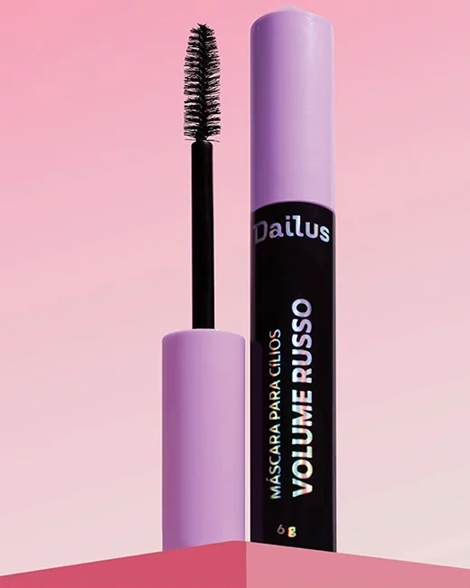 Máscara para cílios com tubo lilás e aplicador de escova em destaque, fundo rosa