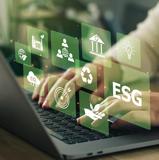 Imagem de uma pessoa usando um laptop, com ícones transparentes e coloridos relacionados a sustentabilidade, meio ambiente, educação, reciclagem, energia, biodiversidade, CO2, metas e ESG flutuando sobre o teclado.